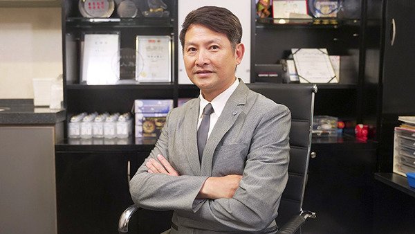 張偉成醫生於書房雙臂交叉展現自信形象
